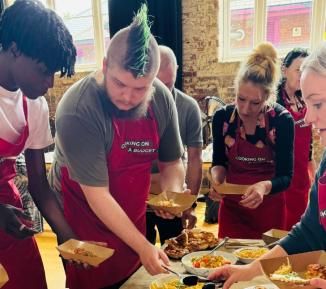 A group of people wearing aprons and sharing food together