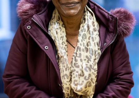 Older woman smiling in a purple coat