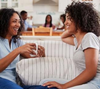 Two women sat on a sofa talking together
