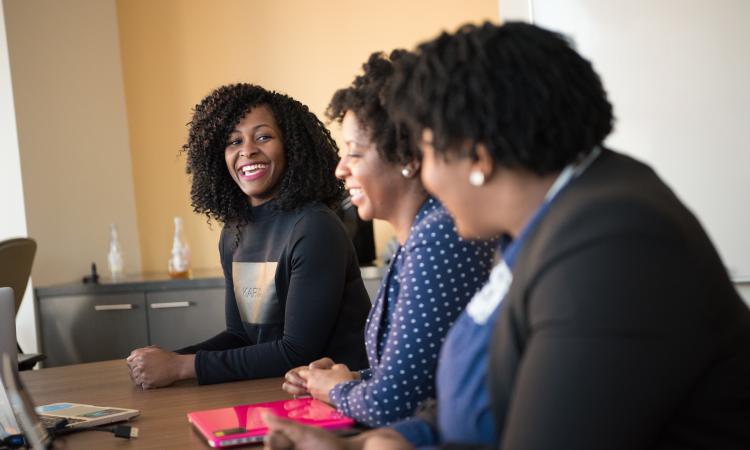 Women in a meeting room smiling