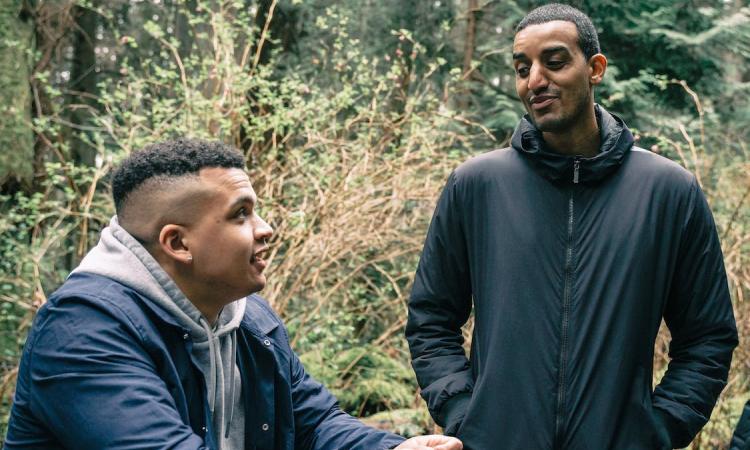 Two young men talking, out in nature