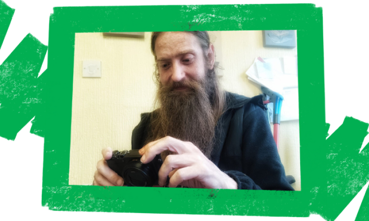 A photo of Tim with his camera in a green hand-drawn frame